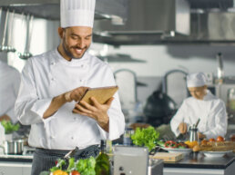 Küchenchef verwendet Tablet-Computer für necta während der Arbeit