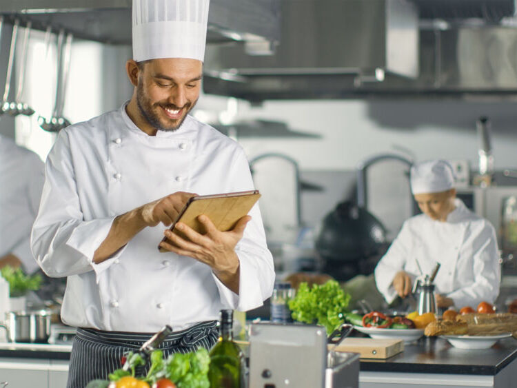 Küchenchef verwendet Tablet-Computer für necta während der Arbeit