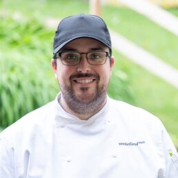 Raphael Huber, K&uuml;chenleiter Vorderlandhus, Portraitfoto in wei&szlig;er Kochuniform